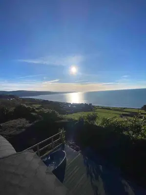 a view of the sun setting over the ocean at Ocean View with hot tub in Barmouth