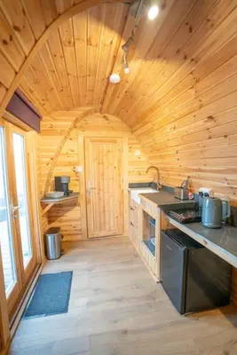 a kitchen in a wooden cabin with a stove at Ocean View with hot tub in Barmouth