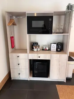 a microwave oven on a wooden shelf with a microwave at Luxury Courtyard Studio in Llangollen in Llangollen