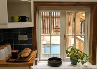 a kitchen with a window and bread on a cutting board at Garden View Apartment in Oswestry