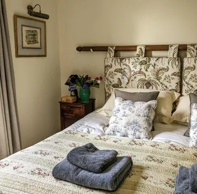 a bed with a pile of towels on it at Garden View Apartment in Oswestry