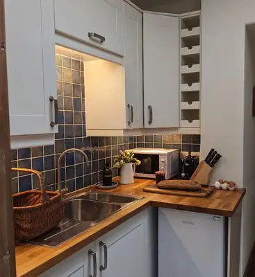 a kitchen with white cabinets and a sink at Garden View Apartment in Oswestry