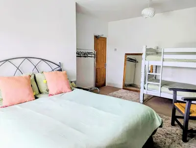 a bedroom with a large white bed and a desk at Family Home in Tywyn - Game and Cinema Rooms in Tywyn