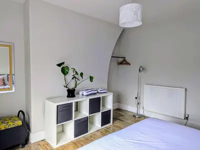 a bedroom with a bed and a white shelf at Family Home in Tywyn - Game and Cinema Rooms in Tywyn
