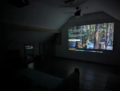 a living room with a big screen tv on the wall at Family Home in Tywyn - Game and Cinema Rooms in Tywyn