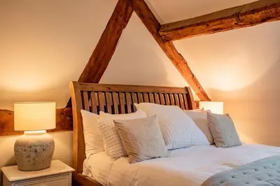 a bedroom with a bed with white pillows at Oak Barn, Ludlow in Ludlow