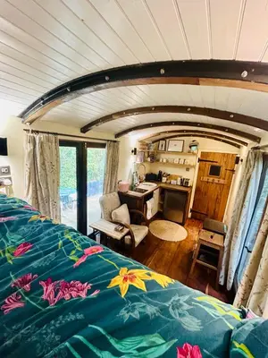 a bedroom with a bed and a desk in a room at The Railway Carriage - Blue in Glasbury