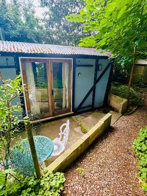 a blue shack with a table and a patio at The Railway Carriage - Blue in Glasbury