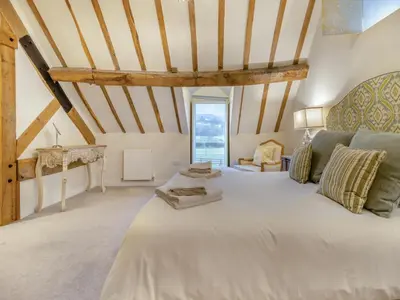 a large white bed in a room with wooden beams at Hares Hollow - Uk33953 in Llanymynech