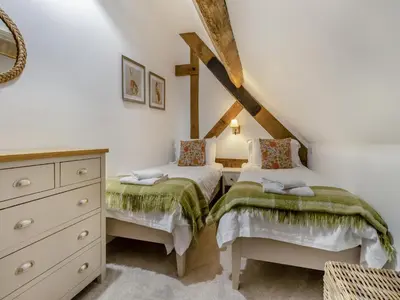 a bedroom with two twin beds and a dresser at Hares Hollow - Uk33953 in Llanymynech