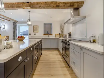 a large kitchen with white counters and stainless steel appliances at Hares Hollow - Uk33953 in Llanymynech
