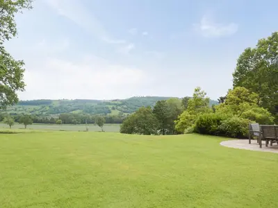 two benches in a park with a view of a field at The Woodshed in Letton