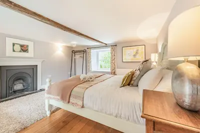 a bedroom with a bed and a fireplace at Ty Glyn Mansion Cottage in Ciliau-Aeron