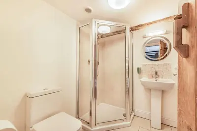 a bathroom with a shower and a toilet and a sink at Ty Glyn Mansion Cottage in Ciliau-Aeron