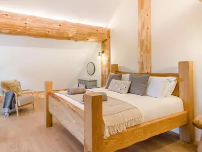 a bedroom with a wooden bed and a chair at Hope Hideaway in Leighton