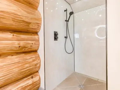 a shower in a bathroom with a wooden wall at Hope Hideaway in Leighton