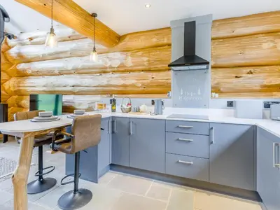 a kitchen with blue cabinets and a wooden wall at Hope Hideaway in Leighton