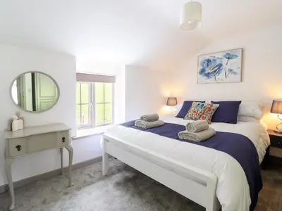a bedroom with a large bed and a mirror at Bwthyn Camlan in Machynlleth
