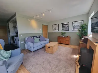a living room with a couch and a table at 1-Bed Apartment - Sleeps 2 & Private Parking in Llansantffraid-ym-Mechain