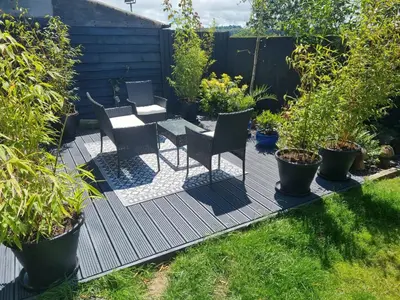 a patio with chairs and a table and some plants at 1-Bed Apartment - Sleeps 2 & Private Parking in Llansantffraid-ym-Mechain