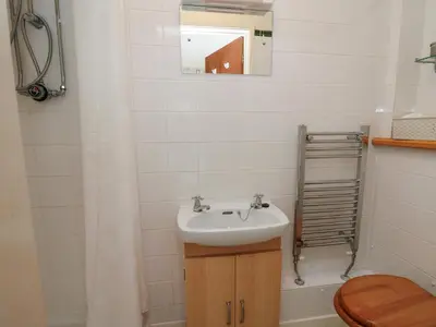a bathroom with a sink and a toilet and a mirror at Nuthatch Cottage at Riverside Lodge in Rhayader