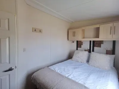 a small bedroom with a bed and a cabinet at Snowdonia Holiday Sea Beach and Mountains view in Llwyngwril