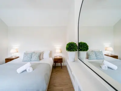 two beds in a white room with two plants at School House Victorian elegance by the river with parking Pass the Keys in Shrewsbury