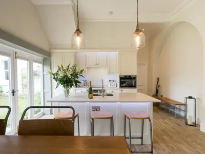 a kitchen with a large white island with bar stools at School House Victorian elegance by the river with parking Pass the Keys in Shrewsbury