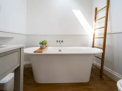 a white bath tub in a bathroom with a ladder at School House Victorian elegance by the river with parking Pass the Keys in Shrewsbury