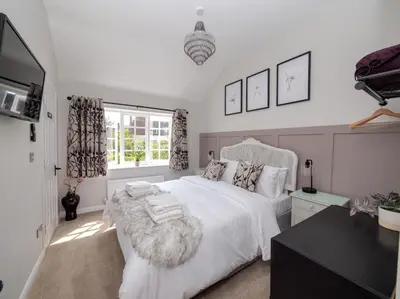 a white bedroom with a white bed and a window at The Lilley Pad in Ludlow Cosy, Central, Perfect for Couples, Netflix & Parking Permit in Ludlow