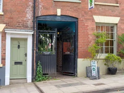an entrance to a brick building with a green door at The Lilley Pad in Ludlow Cosy, Central, Perfect for Couples, Netflix & Parking Permit in Ludlow