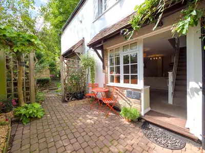 a patio with a table and chairs next to a house at The Lilley Pad in Ludlow Cosy, Central, Perfect for Couples, Netflix & Parking Permit in Ludlow