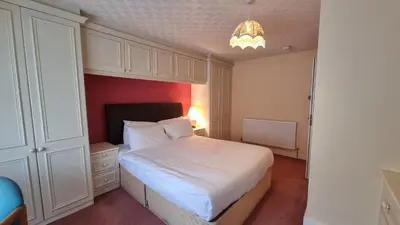 a small bedroom with a white bed and a chandelier at Morawel in Aberystwyth