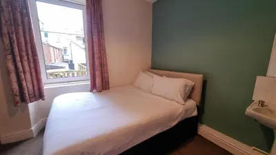 a small bed in a room with a window at Morawel in Aberystwyth