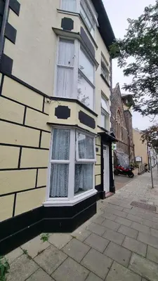 a yellow building with white windows on a street at Morawel in Aberystwyth