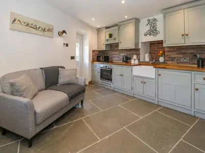 a living room with a couch and a kitchen at Y Bwthyn in Dolgellau