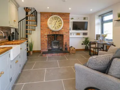 a kitchen and living room with a brick fireplace at Y Bwthyn in Dolgellau