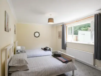 two beds in a room with a window at The Bungalow in Castle Caereinion