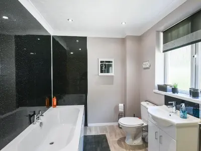 a bathroom with a white tub and a toilet at The Bungalow in Castle Caereinion