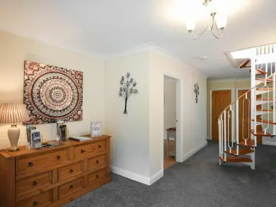 a living room with a wooden dresser and a staircase at The Bungalow in Castle Caereinion