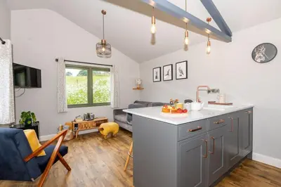 a kitchen with a sink and a living room at Birch Banc Retreats - Glyn-Haul, New Enc Decking in Llanidloes