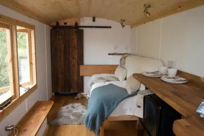 a bedroom with a bed and a wooden table at Little Dolwen - Sioned in Llanwenog