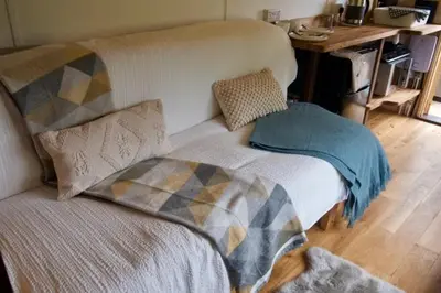 a bed with pillows on it in a room at Little Dolwen - Sioned in Llanwenog
