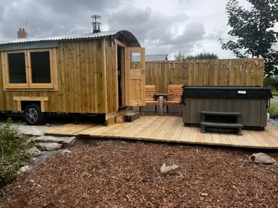 a wooden deck with a table and a fence at Little Dolwen - Sioned in Llanwenog
