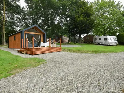 a small cabin with a porch and a trailer at Mini Lodge - Uk47682 in Montgomery
