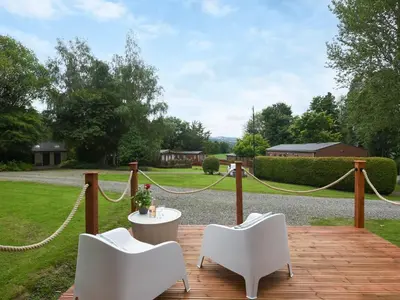 a patio with two white chairs and a table at Mini Lodge - Uk47682 in Montgomery