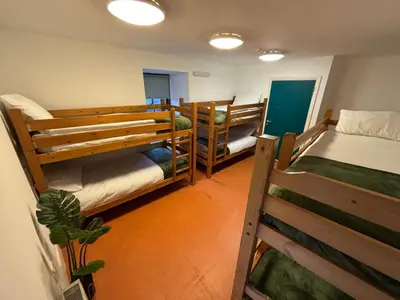 a room with three bunk beds in a room at Llety Glyndwr - Bunkhouse in Trawsfynydd