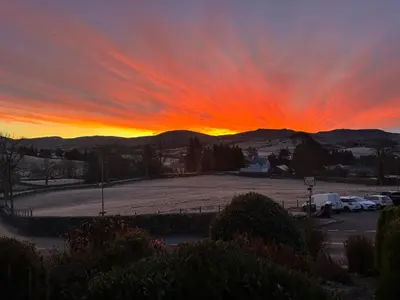 a sunset over a parking lot with a red sky at Llety Glyndwr - Bunkhouse in Trawsfynydd