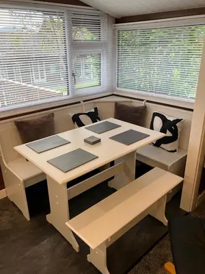 a table and chairs in a room with windows at Snowdonia luxury log cabin in Trawsfynydd