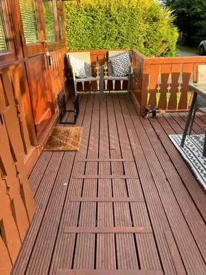 a wooden deck with two chairs and a table at Snowdonia luxury log cabin in Trawsfynydd